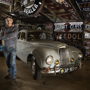 Darryl Williamson is an avid sign collector. He also restored the pictured Sunbeam-Talbot 90 4-Door Saloon 1948. Darryl was photographed for the Men's Sheds project by Craig Wetjen.